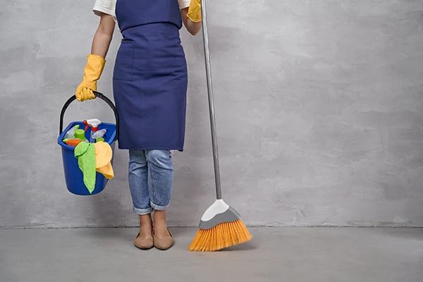 Cleaning services worker with a broom and a cleaning bucket