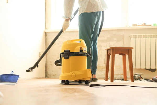 Man cleaning the room during repairs using a construction vacuum cleaner